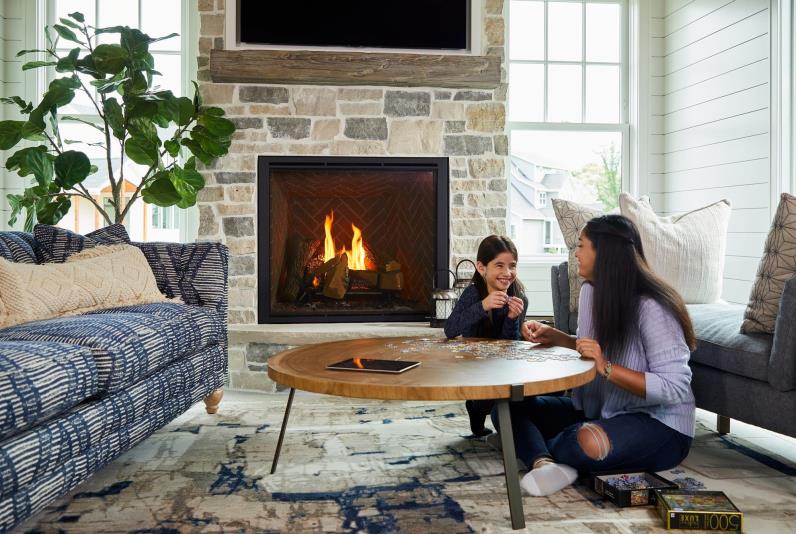 Two sisters working on a puzzle together in front of a Heat & Glo True gas fireplace